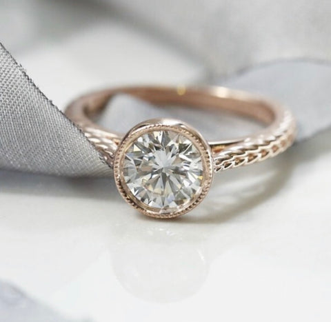 custom bezel set round diamond engagement ring with a milgrain halo and braided band