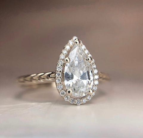 custom pear shaped diamond engagement ring with a delicate diamond halo set in 14k yellow gold with a braided band