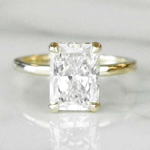 radiant cut diamond engagement ring in 14k yellow gold with a hidden diamond halo