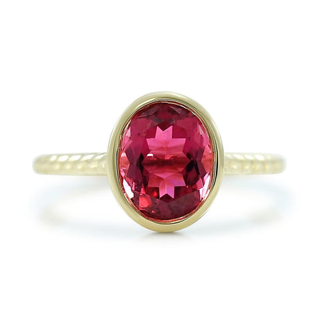 Bezel set pink tourmaline gemstone ring with 14k yellow gold setting and rope band