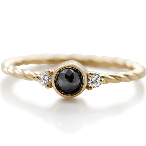 black and white diamond three stone stack ring with a yellow gold braided band