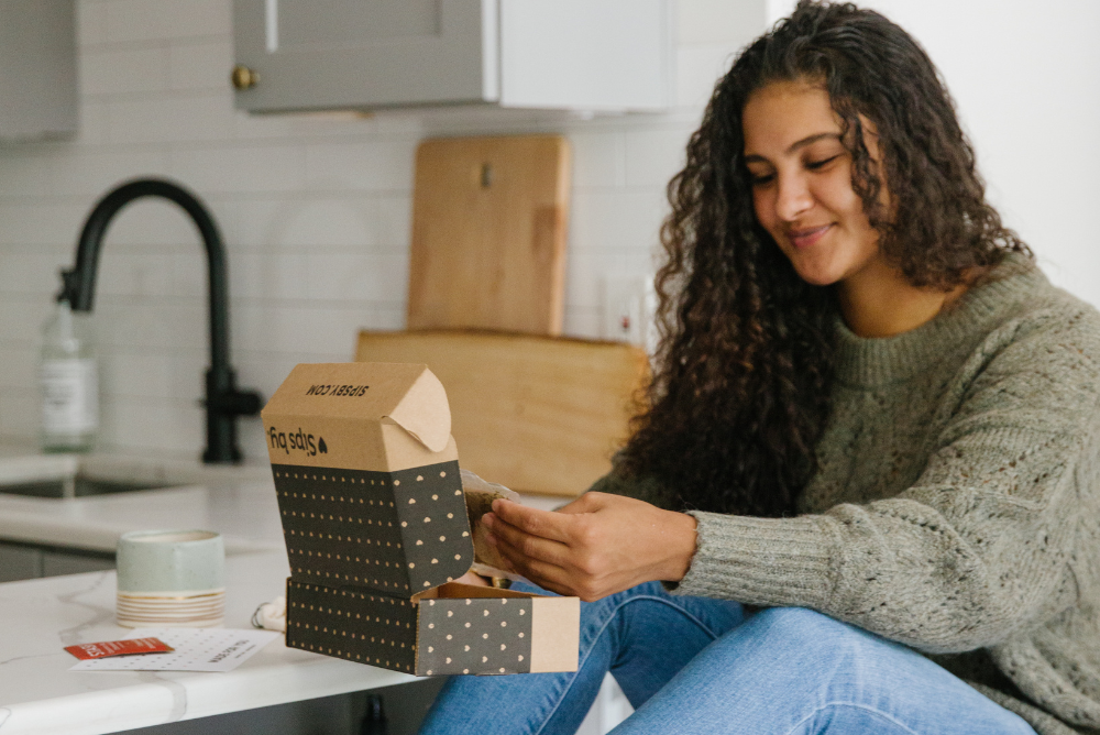 Woman opening a Sips by Box in a kitchen