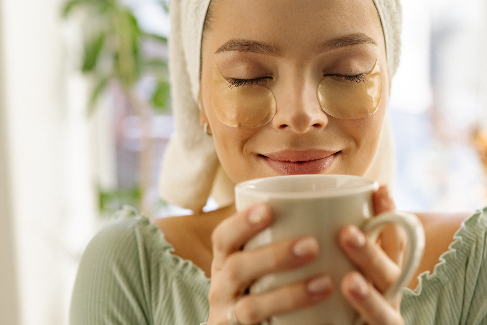 woman in blue sweater drinking a cup of tea