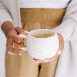 Hands holding a mug with adaptogen tea
