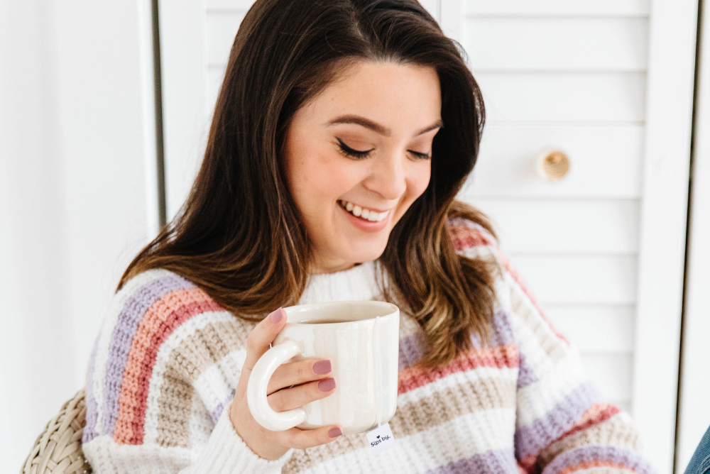 woman smiling with a cup of tea
