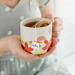 Hands holding a mug with black tea from Sips by