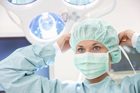 Woman doctor putting on scrub cap