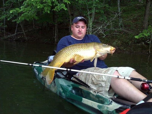 huge carp caught by a guy in small boat targeting catfish