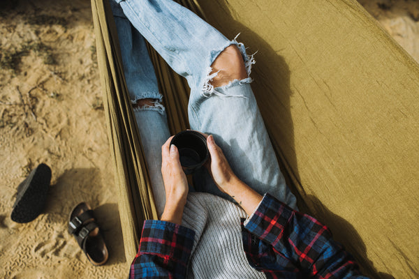 Coffee in a hammock camping. Flannel, Birkenstocks and ripped jeans.