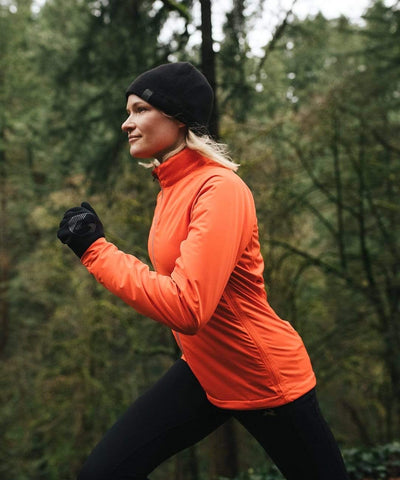 Liz, a Rose City Track Club member, sporting Showers Pass apparel while jogging on a forest trail