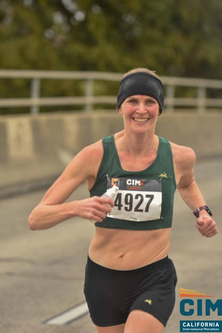 Marla, a Rose City Track Club member, smiling for a photo while running outdoors
