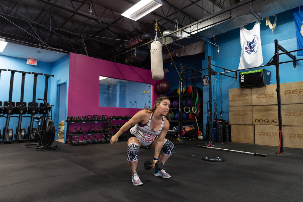 pregnant woman working out and lifting dumbbell