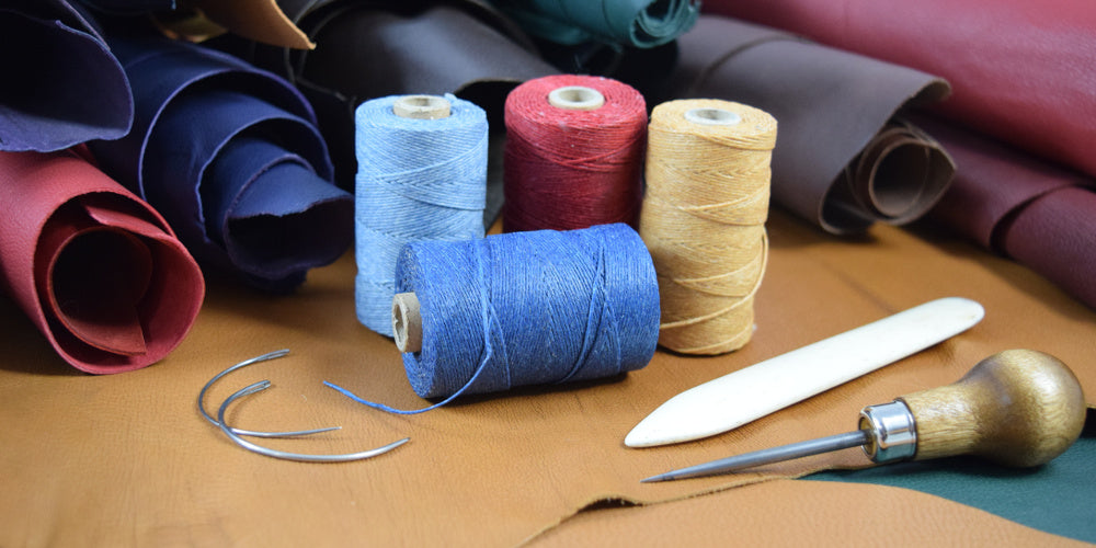 Bookbinding material, veg-tanned leather, linen thread, curved needles, awl
