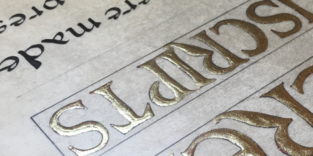 Gold leaf letters and hand letters calligraphy on parchment