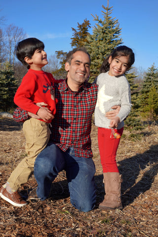 father smiling with his young son and daugther