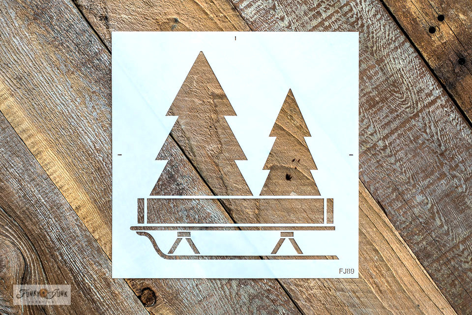 Christmas Trees with Sleigh is a Christmas sign stencil that celebrates creative tree decorating! Designed with two evergreen trees tucked inside a rustic crate tree skirt set on top of a sleigh. The trees are plain so you can decorate them as desired! Sized perfectly for throw pillows or as a Christmas sign.