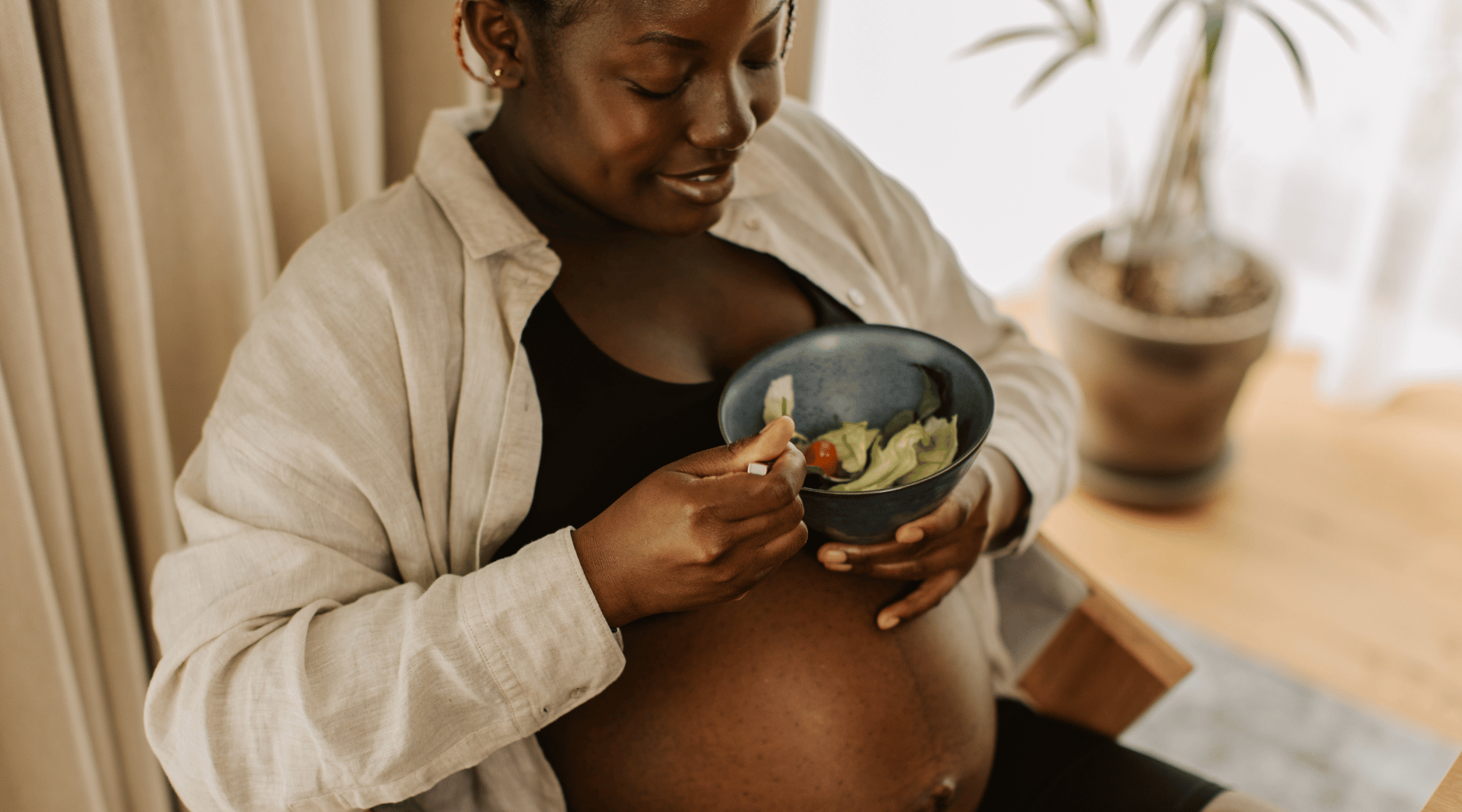 femme noire enceinte avec un bol de salade