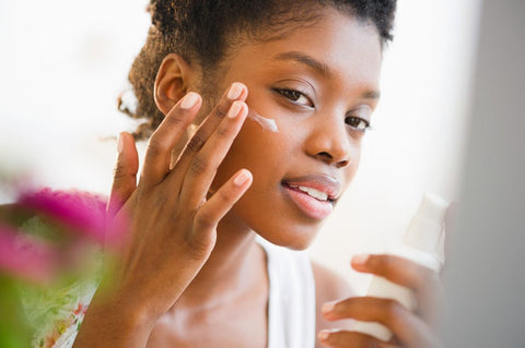 women moisturizing face