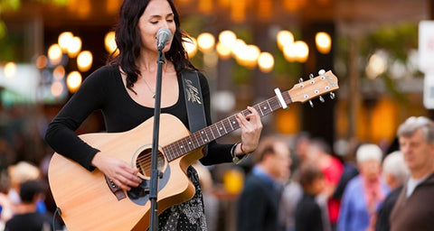 Woman busking with guitar