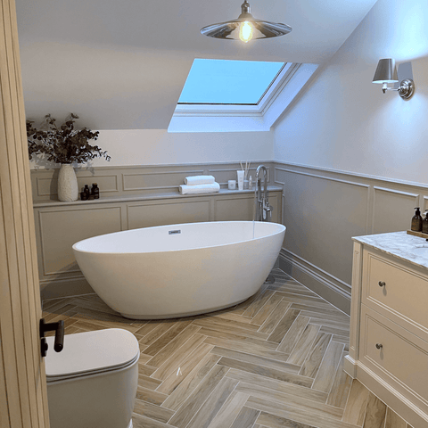 A freestanding tub under a skylight is the perfect spot to enjoy a relaxing soak in the tub, with a stack of fluffy white Hampton and Astley towels on hand.