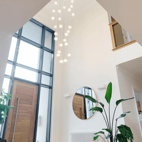 Cascading pendant lights are the perfect choice for this gorgeous two-storey hallway.