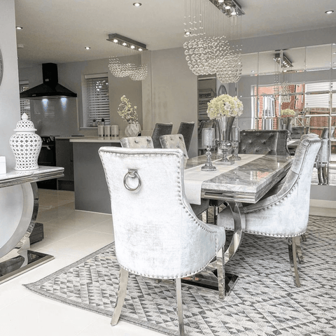 More eye-catching chandeliers light up the open plan kitchen diner, which features a table that looks fit for a king