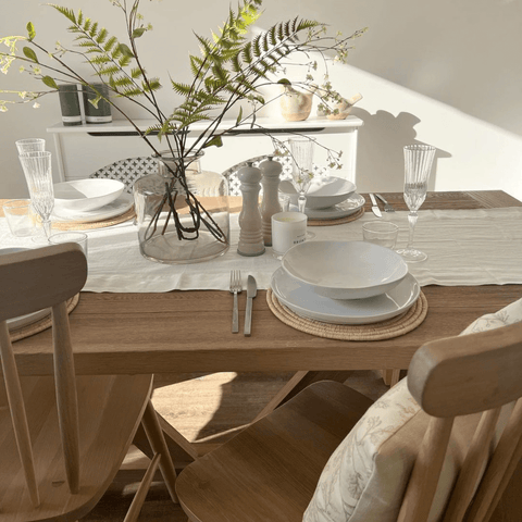 A simple oak table and chairs add a rustic warmth to the dining area.
