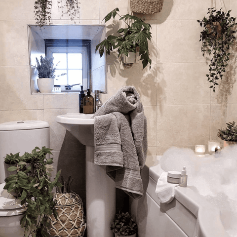 The contemporary style bathroom is given a softer edge with lush hanging baskets and a pile of Hampton and Astley indulgently thick towels in subtle grey