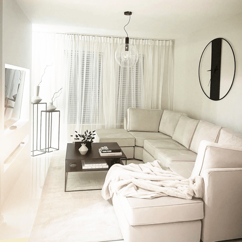 The monochrome themed living area features white vases displayed on tall black tables that have been handcrafted by Tracey.