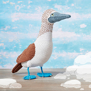 A crocheted bird with bright blue feet