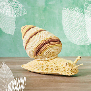 Crochet snail with yellow body and a yellow, brown and cream striped shell