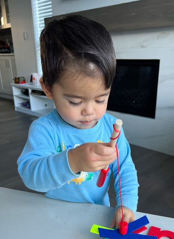 little boy playing with a fishing game