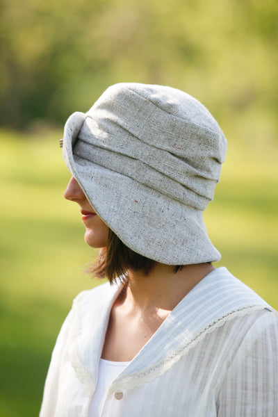 Woman wearing a grey hat facing away from camera.