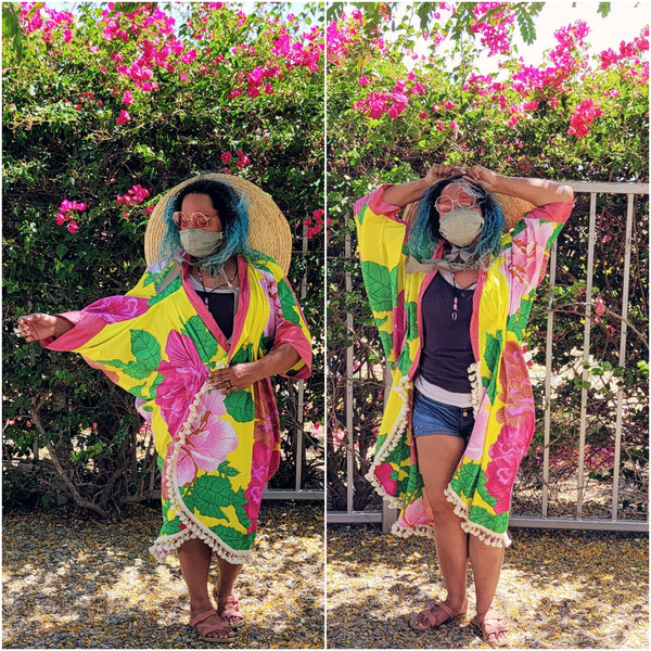 Woman wearing Poirot Cocoon Coat made of a bright yellow and pink African Wax Print.