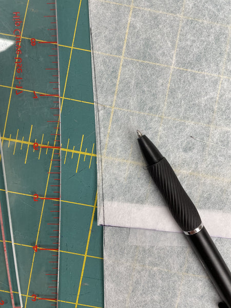 Clean hip ruler with tracing paper and a pen with new lines drawn on paper