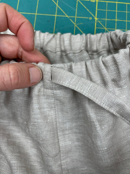 elastic being fed through the front of the waistband of pants