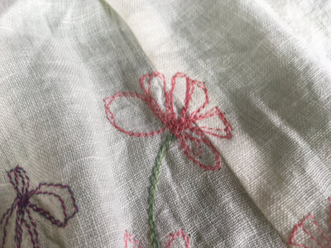 Photo upclose of stitched flower across the seam on the 213 pinafore design