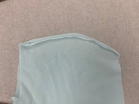 Pressing of curved seam for Bodice Front A aqua light blue fabric, on a light grey background