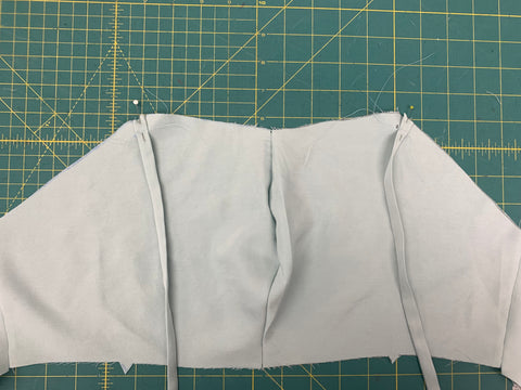 Straps C pinned and basted to front Bodice Front A on a green cutting mat.