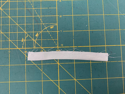 Sewn aqua light blue Band D right sides together at ⅛”/3mm seam allowance on a green cutting mat.