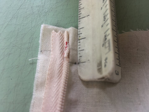 Photo os positioning the zipper from the top edge of the fabric