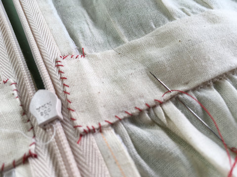 Up close photo of hand whip stitching on waistband facing