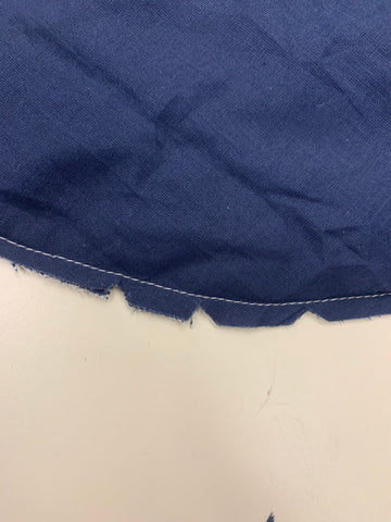 Clipped notches into navy blue fabric on a white background.