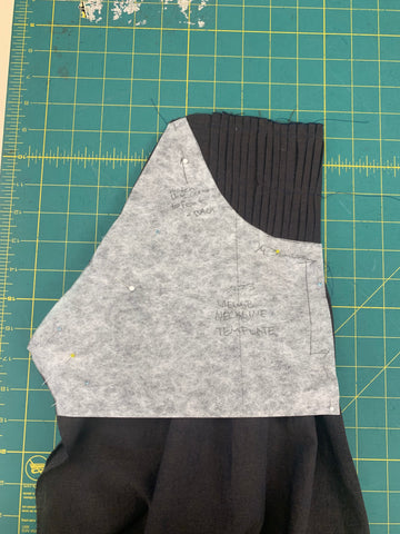 View B neckline placement on pleated bodice front , on a green cutting mat.
