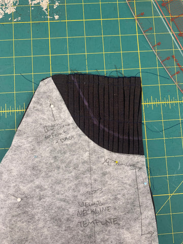 View B neckline placement on pleated bodice front , on a green cutting mat.