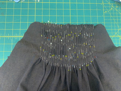Pinned pleats on bodice front on a green cutting mat.