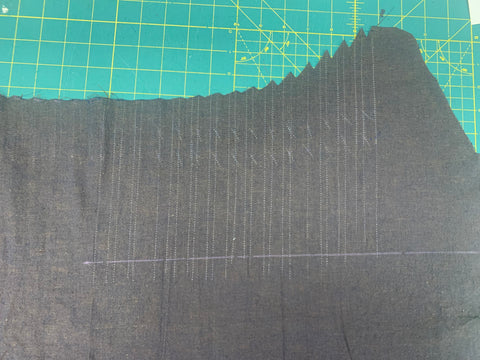 Pleat lines marked on bodice front cut out of a dark plum color fabric with chalk