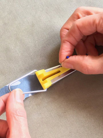 Phot using pin to guide strip through Bias Tape Maker