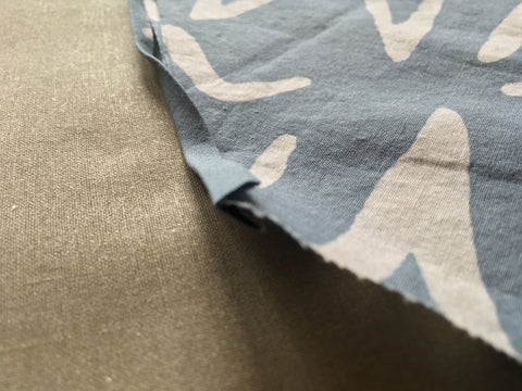 Photo up close of raw egde of fabric sandwiched in fold of bias tape