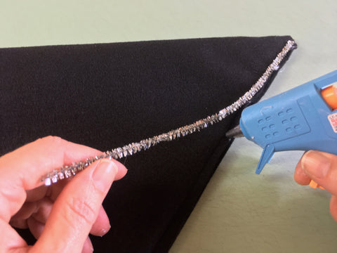 Photo showing gluing pipe-cleaner to hat seam